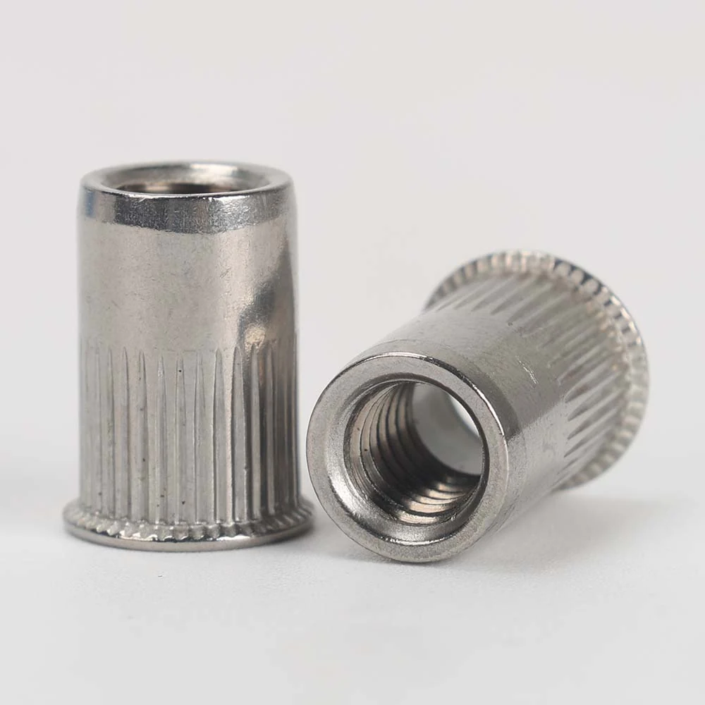 Two small countersunk knurled open-end rivet nuts