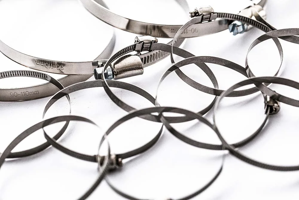 Stainless steel hose clamps arranged on a white background